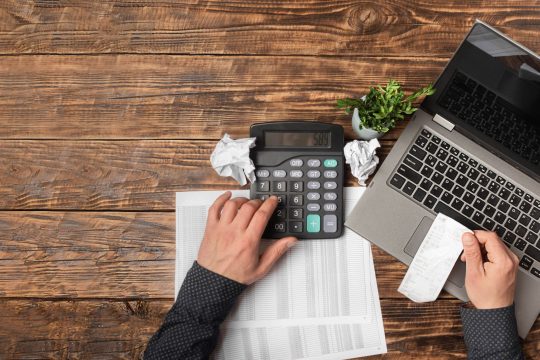 male-hand-holding-a-check-and-using-a-calculator-w-2021-11-12-06-15-50-utc-min